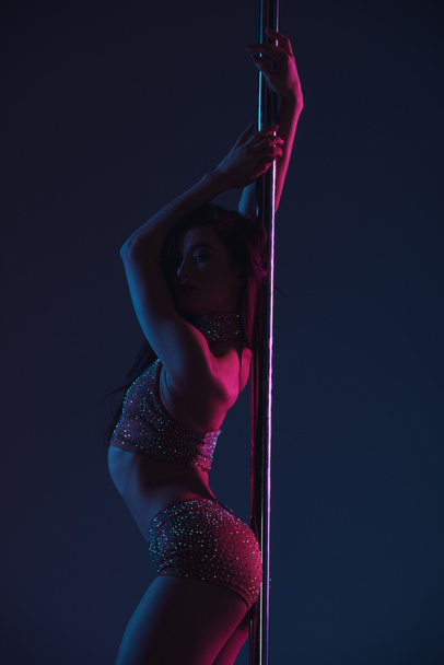 beautiful seductive young woman posing with pole on blue - Foto, imagen