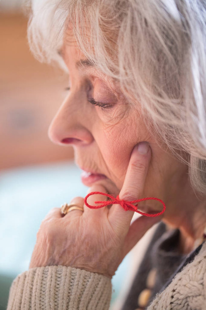 Close Up Of Senior Woman With String Tied Around Finger As Remin - Foto, Imagen