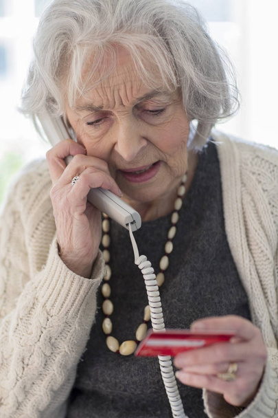 Senior Woman Giving Credit Card Details On The Phone - Foto, Bild