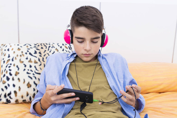 jovem adolescente com um telefone celular ouvindo música ou tocando
 - Foto, Imagem
