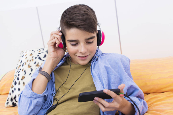 adolescente joven con un teléfono móvil escuchando música o tocando
 - Foto, imagen