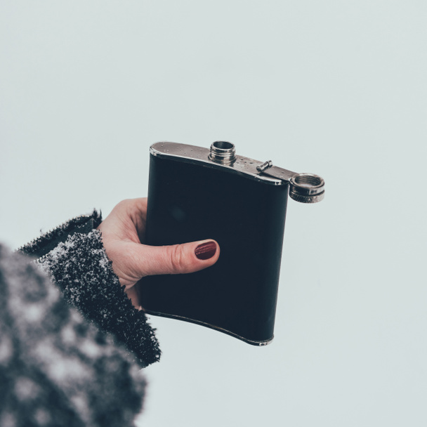 cropped shot of woman holding flask in hand on winter day - Foto, afbeelding