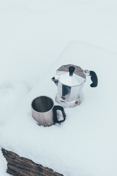 κλείνω πάνω θέα του Κυπέλλου και καφετιέρα στο χιόνι - Φωτογραφία, εικόνα