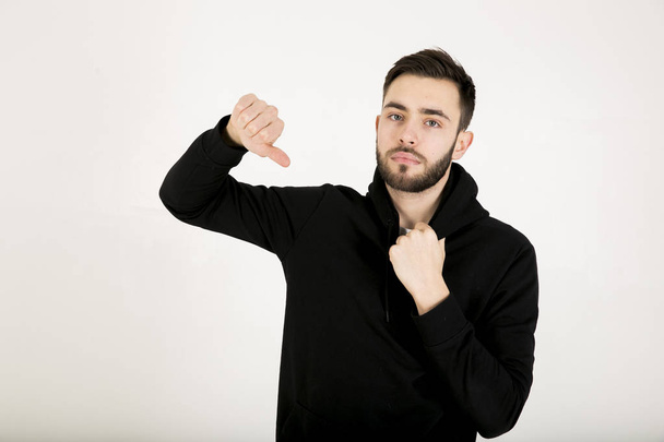 atraktivní mladý muž s malým vousy v černých šatech, stojím - Fotografie, Obrázek