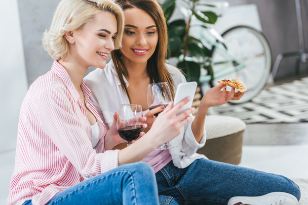 belles femmes avec du vin et de la pizza en utilisant smartphone
 - Photo, image