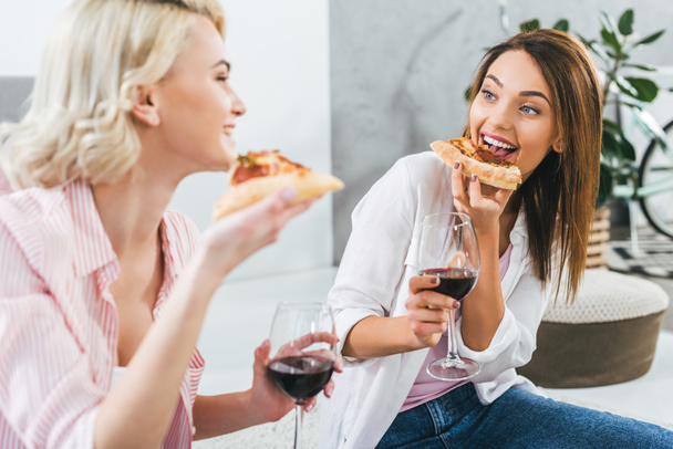 happy girls drinking red wine and eating pizza - Photo, image
