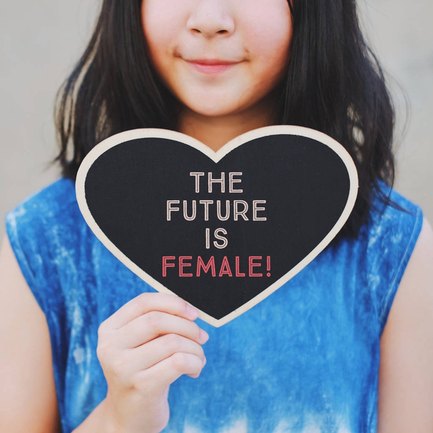 Вдохновляющий лозунг мотивации будущее женщины на доске в форме сердца на женской руке, цитата из феминизма
 - Фото, изображение