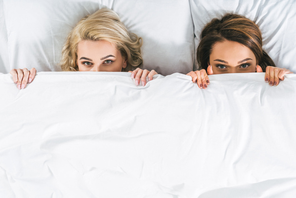pohled shora atraktivních žen, ležící v posteli - Fotografie, Obrázek