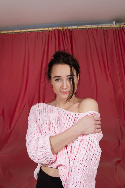 girl in a pink sweater on a bed in the bedroom - Foto, Bild