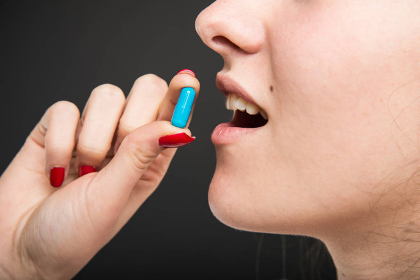 Primer plano de la boca del médico femenino que toma una pastilla
  - Foto, imagen