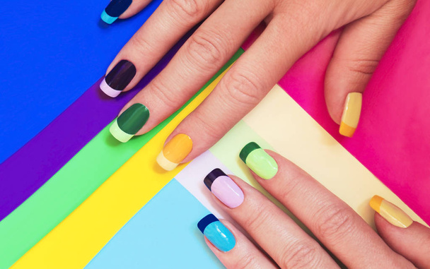 Multi-colored pastel manicure combined tone on tone with a striped background.Nail art. - Фото, зображення