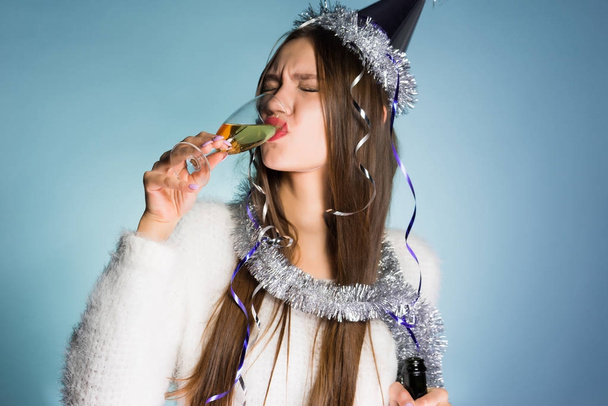 drunk woman in a holiday hat drinking champagne - Фото, изображение