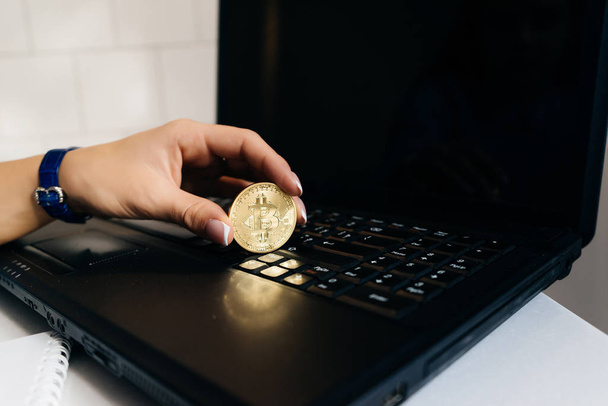 woman holds a crypto currency on a laptop background - Fotoğraf, Görsel