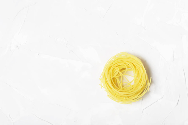 Raw spaghetti on white cement textured background - Foto, immagini