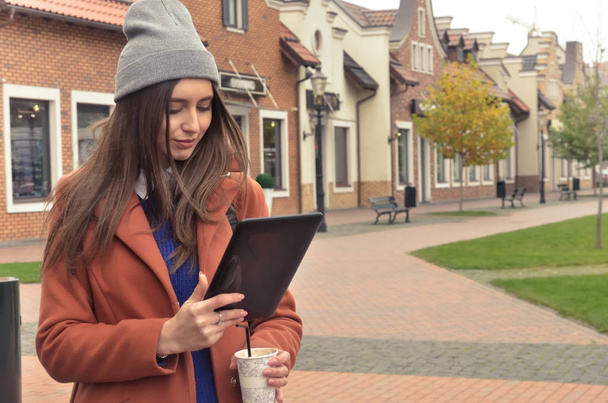 A young woman standing outdoor with black tablet - Foto, Bild