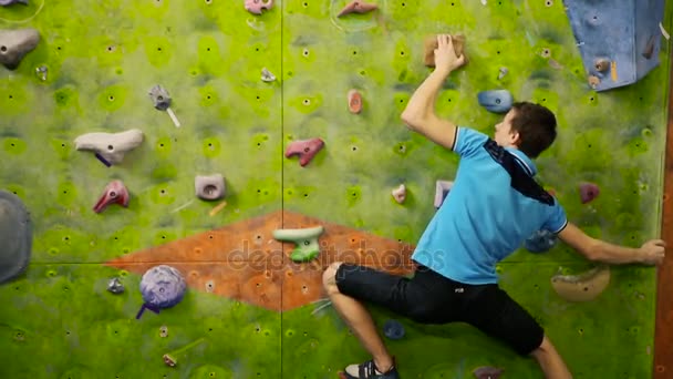 Εσωτερική εκπαίδευση ορειβάτης υπερνικά τον τοίχο στο δωμάτιο γυμναστήριο. - Πλάνα, βίντεο