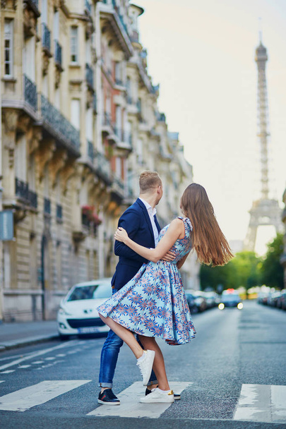 Romantic couple kissing on the street with Eiffel tower in background in Paris, France - Foto, Bild