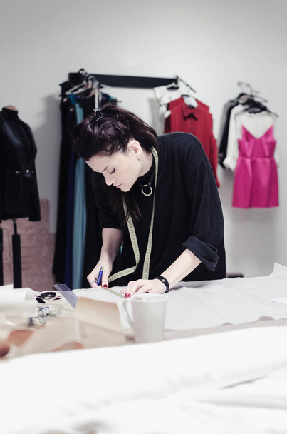Female fashion designer working in studio at tailor shop - Foto, Imagem