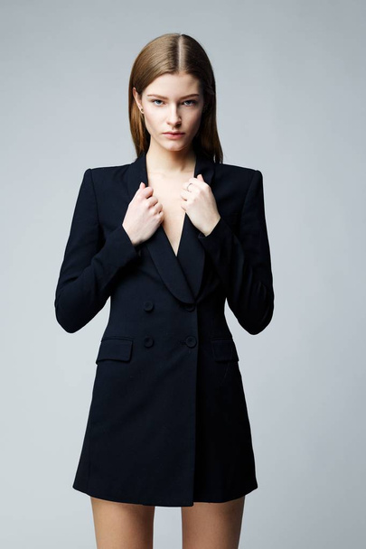 Gorgeous fashion model in black fashionable jacket posing against studio background - Valokuva, kuva