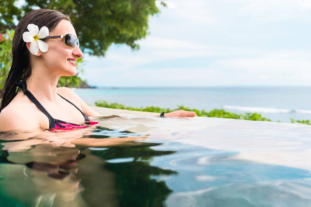 Woman in vacation relaxing swimming in pool - Photo, Image