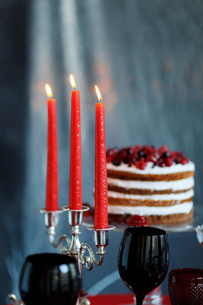 Вкусный сладкий шведский стол с ягодным тортом и бокалами с шампанским на красном столе
 - Фото, изображение