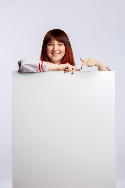 Picture of brunette cook in white coat with empty poster - Foto, immagini
