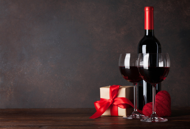 Tarjeta de felicitación de San Valentín con vino tinto, corazón decorativo y caja de regalo en mesa de madera. Con pizarra
 - Foto, Imagen