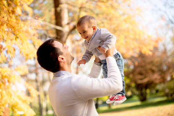 Young father and baby boy in autumn park - Foto, afbeelding