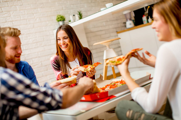 Gruppe junger Freunde isst zu Hause Pizza - Foto, Bild