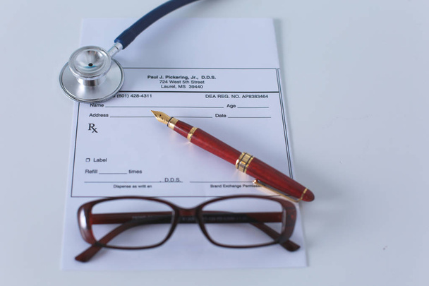zdravotní stetoskop a brýle leží na stole - Fotografie, Obrázek