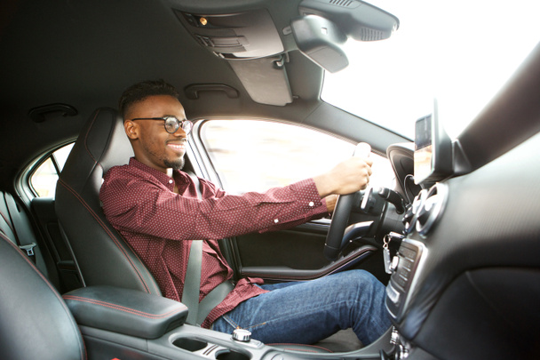 Po stronie portret szczęśliwy młody czarny facet jazdy samochodem - Zdjęcie, obraz