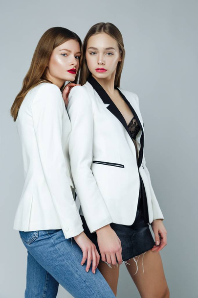 Two stylish fashion models posing against studio background - Photo, Image