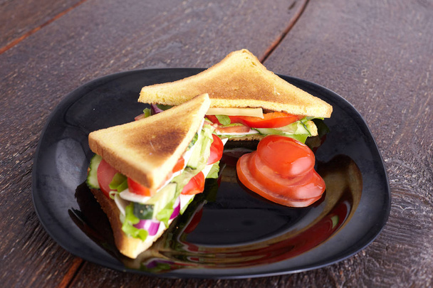 Sağlıklı sandviç yumuşak peynir ve çiğ bahar sebzeler gevrek siyah ekmek üzerinde - Fotoğraf, Görsel