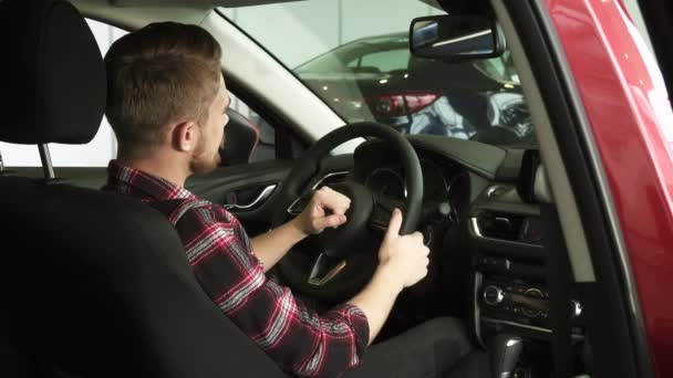 Vrolijke knappe mannelijke klant weergegeven: duimschroef opwaarts zitten in een nieuwe auto bij de dealer - Video
