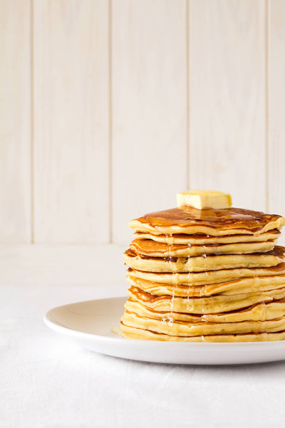 Stack of pancakes with butter and honey on white background - Foto, immagini