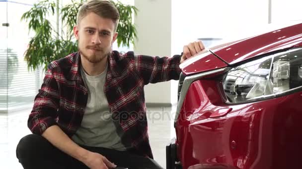 Onnellinen komea mies poseeraa hänen uusi auto näyttää auton avaimet kameraan
 - Materiaali, video