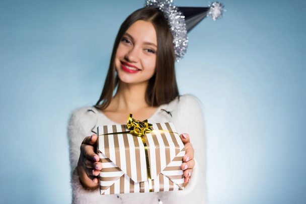 happy woman in festive cap holding hands gift - Valokuva, kuva