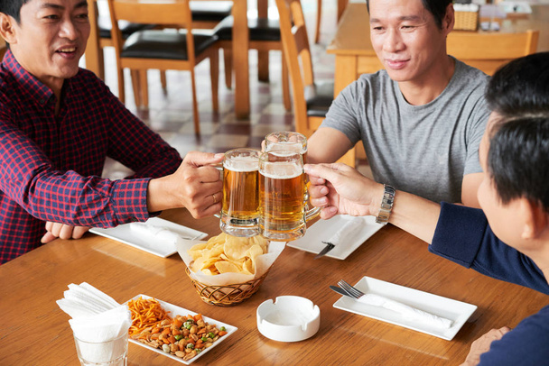 Asian mature men toasting with fresh beer - Photo, Image