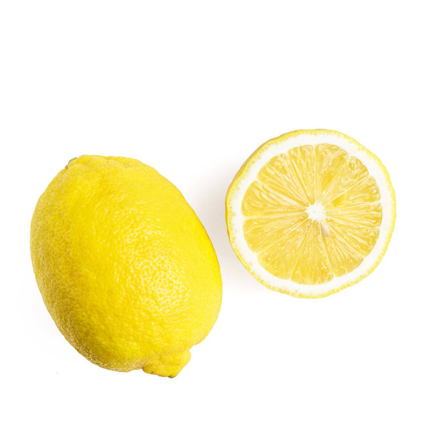 Una fruta entera y la mitad de limón amarillo maduro, aislado sobre un fondo blanco, vista superior
. - Foto, Imagen