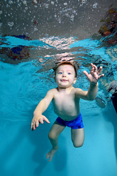 Ανοίξτε το μωρό κολυμπά κάτω από το νερό στην πισίνα με τα μάτια μου. Πορτρέτο. Κατακόρυφο προσανατολισμό - Φωτογραφία, εικόνα