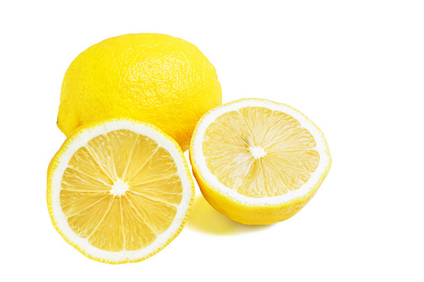 Kokonainen ja kaksi puolikasta keltaisia kypsiä sitruunan hedelmiä, eristetty valkoisella pohjalla
. - Valokuva, kuva