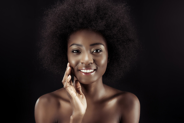 happy african american woman touching her face isolated on black - Фото, изображение
