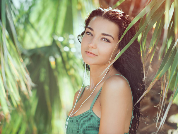 Tropical girl listening to music on earphones - Foto, Imagem