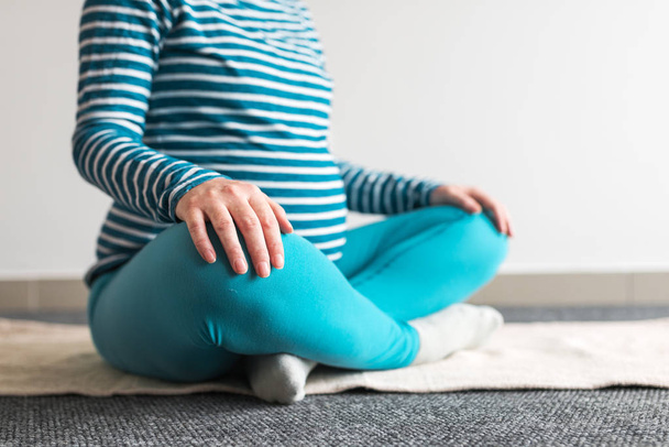 Pregnant woman practicing yoga exercise at home. - Fotó, kép