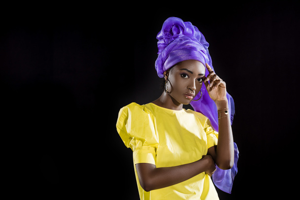attractive african american woman in purple wire head wrap clothing isolated on black - Photo, Image