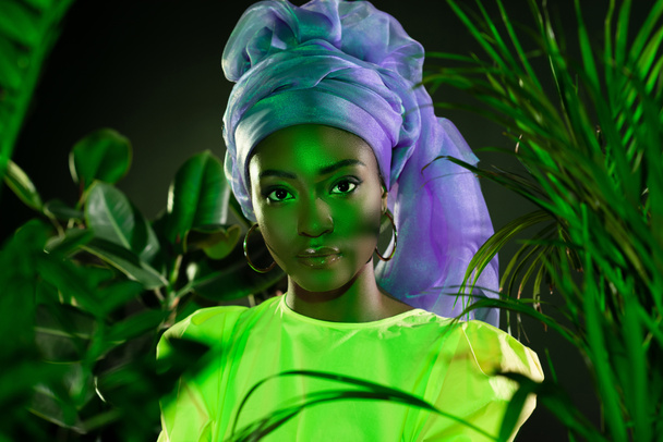 όμορφη αφρικανική αμερικανική γυναίκα στο παραδοσιακό σύρμα κεφάλι τυλίξτε κάτω από το πράσινο φως που βλέπουν τα φωτογραφικών μηχανών - Φωτογραφία, εικόνα