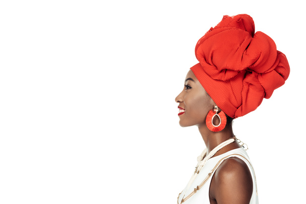 vista lateral de mujer afroamericana en accesorios étnicos aislados en blanco
 - Foto, imagen