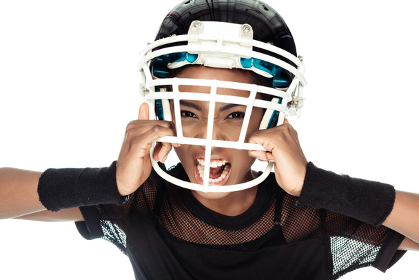 high angle view of agressive female american football player trying to take off her helmet isolated on white - Фото, изображение