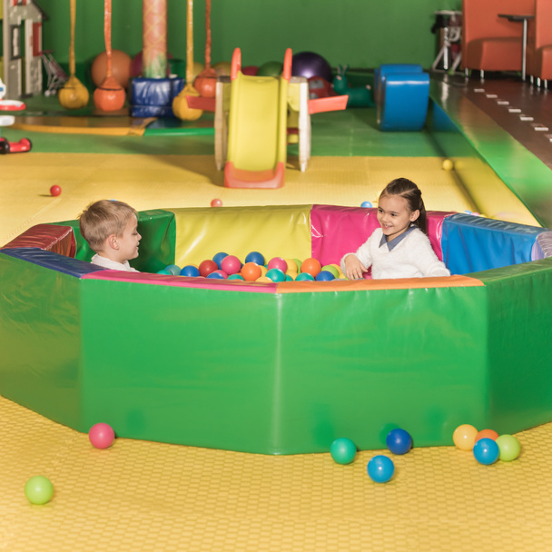 adorable happy little children playing in pool with colorful balls - Foto, Imagen