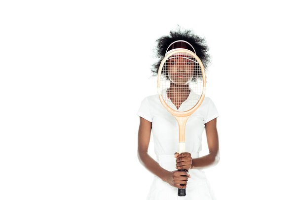 γυναικείο τένις παίκτης που κρατάει ρακέτα μπροστά από το πρόσωπό που απομονώνονται σε λευκό - Φωτογραφία, εικόνα